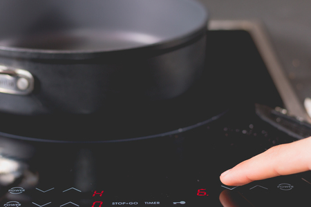 Cook who starts Induction Cooktops in a kitchenの写真素材