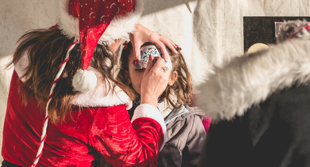 Bretignolles sur Mer, France - December 18, 2016 : During the Christmas period, a little girl is applying makeup in a stand on a Christmas marketのeditorial素材
