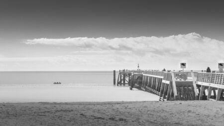 Wooden pontoon overlooking the ocean in mixed weather. in black and whiteの写真素材