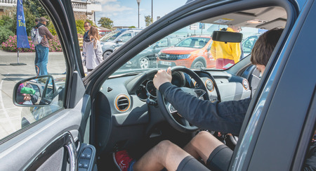 Sables d Olonne, France - May 07, 2017: Dacia Tour 2017 is a commercial operation organized by the car builder in order to present its cars throughout France - A young man watching a carのeditorial素材
