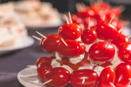 little cocktail tomatoes with cheese on peak on a plateの写真素材