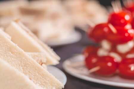 Delicious little cocktail sandwich with tomatoes on a black tableclothの写真素材
