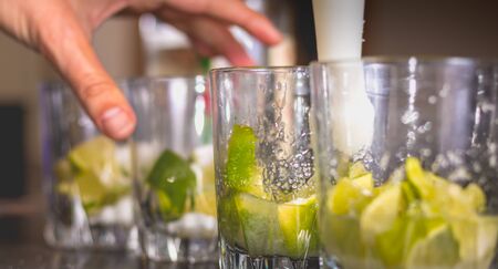 barman crushes green lemons with a pill to make caipirihnas bresillianの写真素材