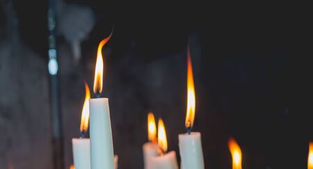 Lighted candles in the chapel of Lourdes, religious symbolsの写真素材