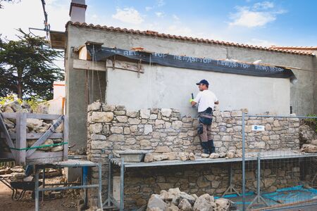 NOIRMOUTIER, FRANCE - june 16, 2017: mason renovates a house with stone in the tradition of NOIRMOUTIER, FRANCEのeditorial素材