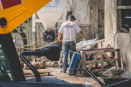 NOIRMOUTIER, FRANCE - june 16, 2017: worker cleans his equipment on a renovation projectのeditorial素材