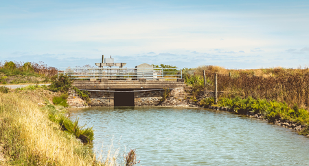 Ancient small stone bridge with a lock that feeds the salt marshes of Noirmoutier, Franceのeditorial素材