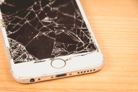 Paris, FRANCE - August 26, 2017: on a wooden background, a white iPhone 6S developed by the company Apple Inc., whose screen is broken after a violent fallのeditorial素材