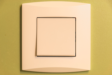 close up residential wall switch on a green wall