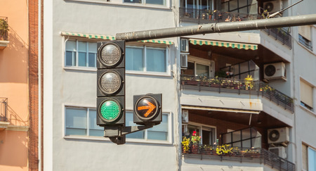VALENCIA, SPAIN - June 18, 2017 : traffic light green with yellow arrow on rightのeditorial素材