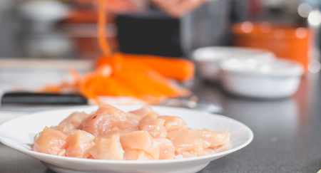 Cook frying chicken in a pan of oil on induction platesの写真素材