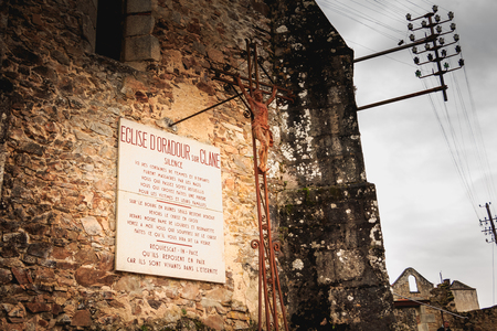 ORADOUR SUR GLANE, FRANCE - December 03, 2017 : on the church destroyed by fire a stone panel where it is written in French - SILENCE here hundreds of women and children were massacred.のeditorial素材