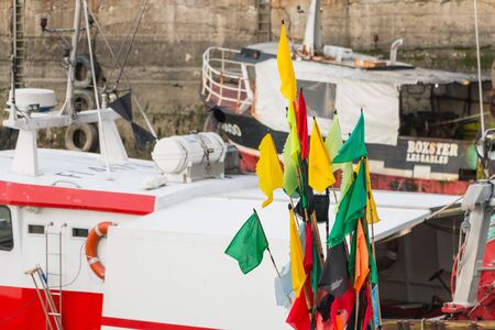 Sables d Olonne, France - March 16, 2017 : closeup of flags hung on floats on fishing boats near starting at the end of winterのeditorial素材