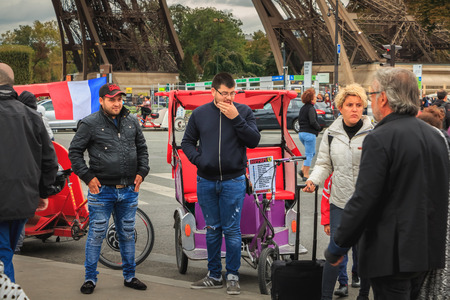 Paris, France - October 08, 2017 : Rickshaw drivers wait for customers next to the Eiffel Tower on a...