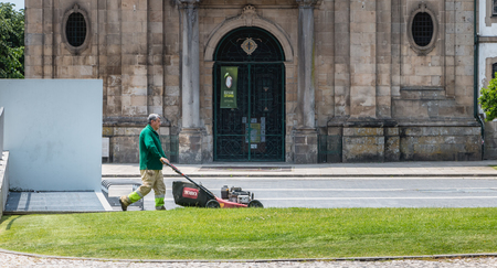 Braga, Portugal - May 23, 2018: Municipal gardeners mowing the grass in the city center on a spring dayのeditorial素材