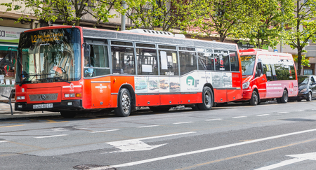 Irun, Spain - April 27, 2018: Public bus stopped at a station near a sidewalk where people walk a spring dayのeditorial素材