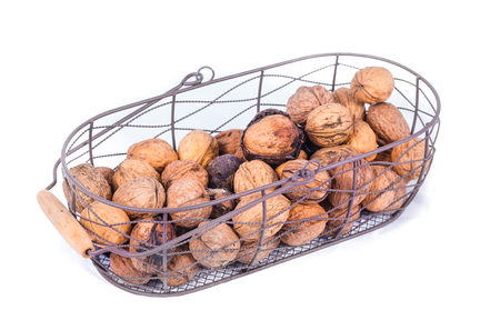 group of seasonal autumn nuts in a metal basket isolated on white backgroundの写真素材