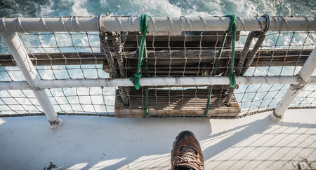 relaxed man sitting at the back of a ferry leaving the port towards Yeu Islandの写真素材