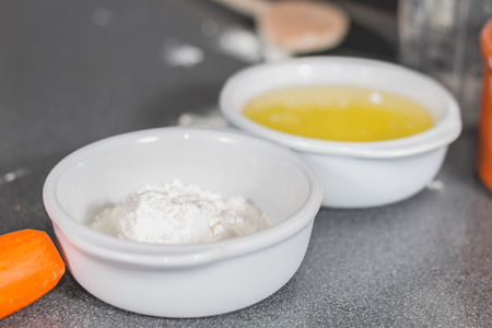 white flour and eggs in a ramekin on the kitchen work surfaceの写真素材