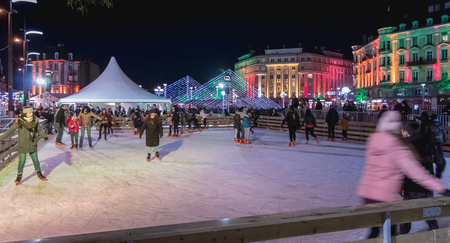 Belfort, France - December 26, 2017: Happy people gliding by night on the ice rink installed downtown at a Christmas marketのeditorial素材