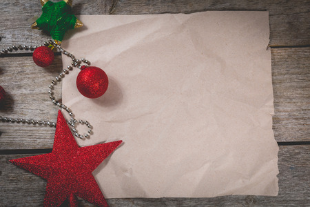 happy christmas concept with red decoration on old wooden board and writing space on paperの写真素材