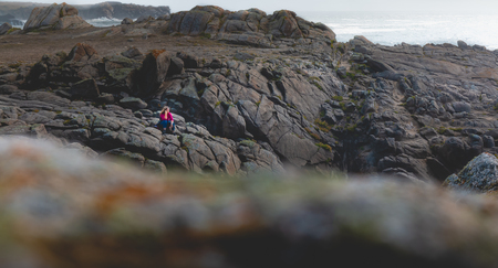 young woman sitting on rocks near the sea of the island of Yeuの写真素材