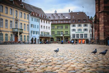 Freiburg im Breisgau, Germany - December 31, 2017: People dressed warmly walking on the paved square of the cathedral on a winter dayのeditorial素材