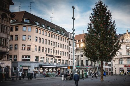Basel, Switzerland - December 25, 2017 - people walk quietly on the market place decorated with his Christmas tree for the end of the year partiesのeditorial素材