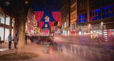 Strasbourg, France - December 28, 2017: People dressed warmly walking in the evening in a pedestrian street and shopping decorated for the Christmas season on a winter dayのeditorial素材