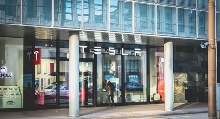 Basel, Switzerland - December 25, 2017: A man looks at the window of a luxury Tesla car brand agency in the historic city center on a winter dayのeditorial素材