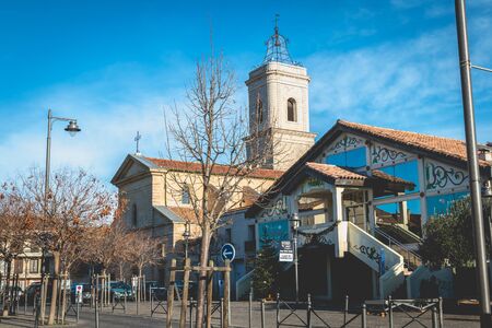 Marseillan, France - December 30, 2018: architectural detail of the Saint Jean-Baptiste church and the La Fabrique media library in the historic city center on a winter dayのeditorial素材