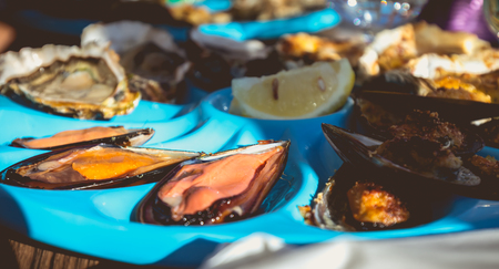 dish of oysters and mussels cooked and raw on a table near the sea in the south of Franceの写真素材
