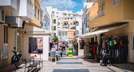 Quarteira, Portugal - May 1, 2018: Downtown shopping street atmosphere where people are walking on a spring dayのeditorial素材