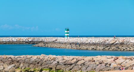Quarteira, Portugal - May 1, 2018: People walking by the sea on a spring dayのeditorial素材