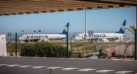 Faro, Portugal - May 3, 2018: behind the outer gates, planes parked on the tarmac of Faro International Airport on a spring dayのeditorial素材