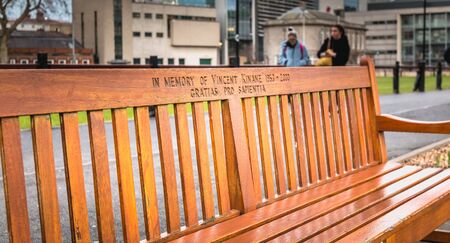 Dublin, Ireland - 11 February 2019: Wooden bench where it is written In memory of Vincent Kinane 1953 - 2000 in the city center on a winter dayのeditorial素材