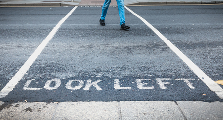 Look Left painted in white on the road on a pedestrian crossing in the city center on a winter dayの写真素材