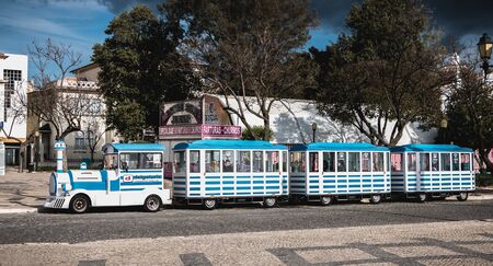 Faro, Portugal - May 1, 2018: Small tourist train circling the city in the historic city center on a...