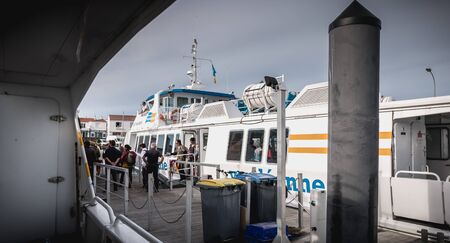 Ile d Yeu, France - September 16, 2018: ferry that enters the harbor of the island of Yeu where travelers are sitting to admire the show on a summer dayのeditorial素材
