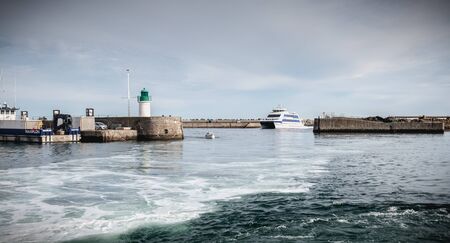 Ile d Yeu, France - September 16, 2018: ferry that enters the harbor of the island of Yeu where travelers are sitting to admire the show on a summer dayのeditorial素材