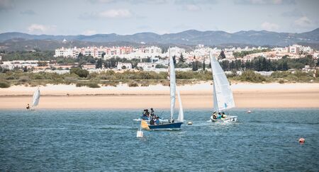 Tavira Island, Portugal - May 3, 2018: People dressed as sailor taking a boat lesson on the Ria...
