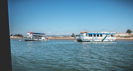 Tavira, Portugal - May 3, 2018: Tourist transport boats moored in the lagoons of the Ria Formosa Natural Park near the port of Tavira on a spring dayのeditorial素材