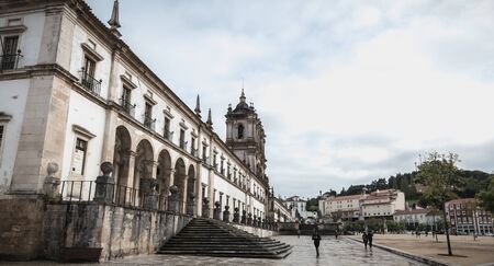 Alcobaca, Portugal - April 13, 2019: People walk in the rain in front of Alcobaca Monastery, Portugal on a spring dayのeditorial素材