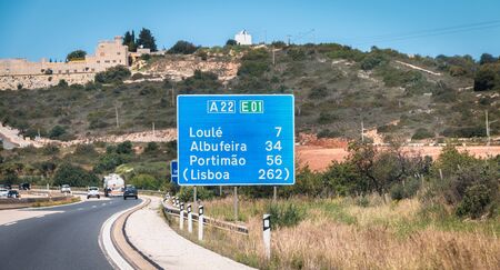 Faro, Portugal - September 16, 2018: blue road sign on A22 highway indicating the direction of Lisbon, Portugal on a summer dayのeditorial素材