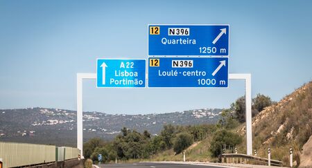 Faro, Portugal - September 16, 2018: blue road sign on A22 highway indicating the direction of...