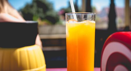 orange juice seated on the table of a terrace of coffee outsideの写真素材
