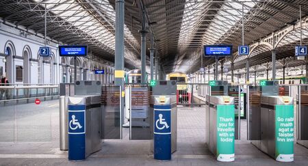 Dublin, Ireland - February 13, 2019: Access turnstile at the platform at Heuston station where trains are parked on a winter dayのeditorial素材