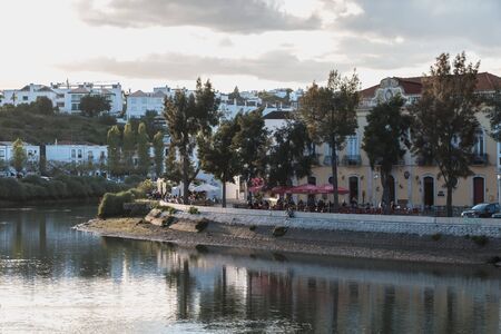 Tavira, Portugal - April 30, 2018: View of terraces of retaurants along the river where people eat and walk on a spring dayのeditorial素材