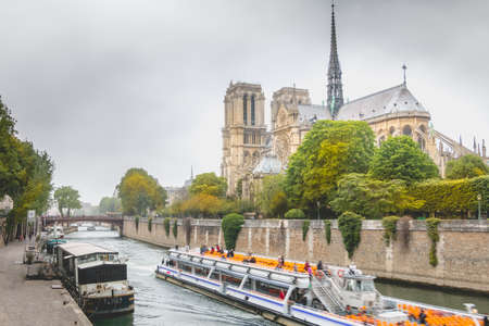Paris, France - May 8, 2017 - Side view of Notre Dame Cathedral on the Seine with barges on a spring dayのeditorial素材