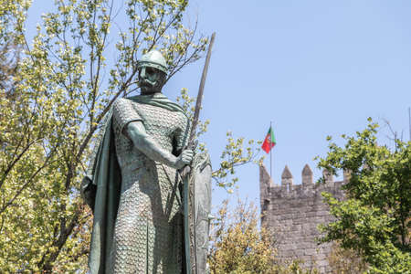 Guimaraes, Portugal - May 10, 2018: statue of the first king of Portugal, D. Afonso Henriques by the sculptor Antonio Soares dos Reis in front of the castle of Guimaraes that tourists are visiting on a spring dayのeditorial素材